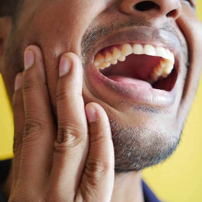 homme se tenant la âchoire