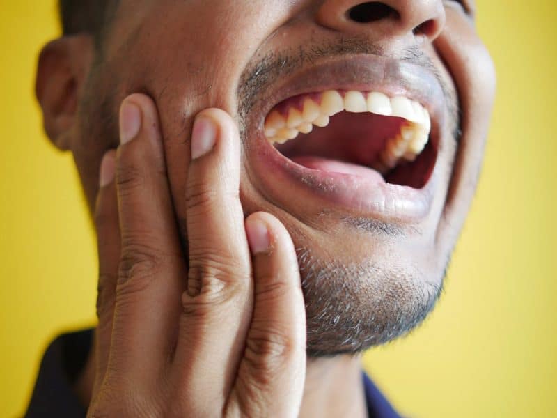 homme se tenant la âchoire