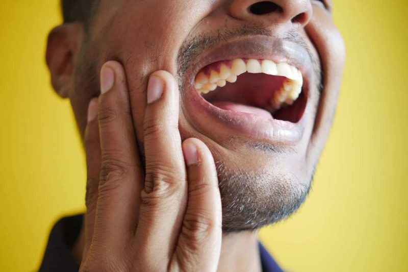 homme se tenant la âchoire