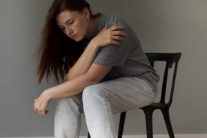 full-shot-sad-woman-sitting-chair