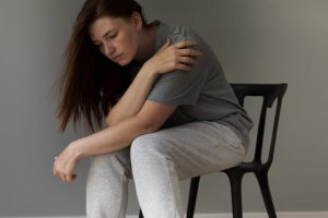 full-shot-sad-woman-sitting-chair