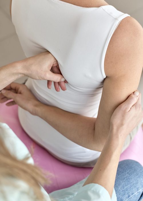physiotherapist-undergoing-therapy-with-female-patient