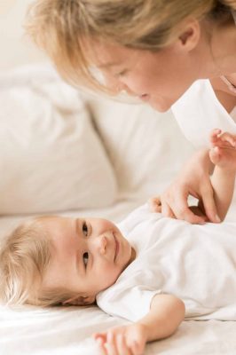 portrait-mom-baby-snuggling-bed