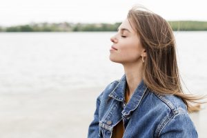 side-view-woman-enjoying-sea-breeze (1)